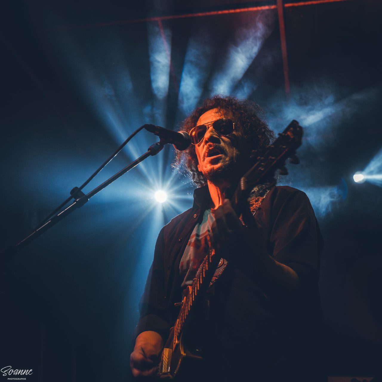 Guitariste de Kingston Calling sous une lumière bleue, aux Estivales du Guilvinec (2025)
