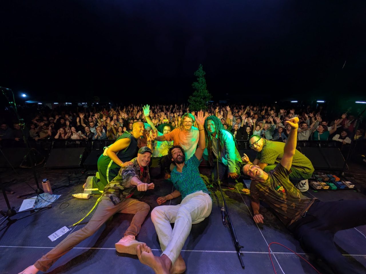 Les musiciens de Kingston Calling assis au bord de la scène, la foule derrière eux, tournée 2026